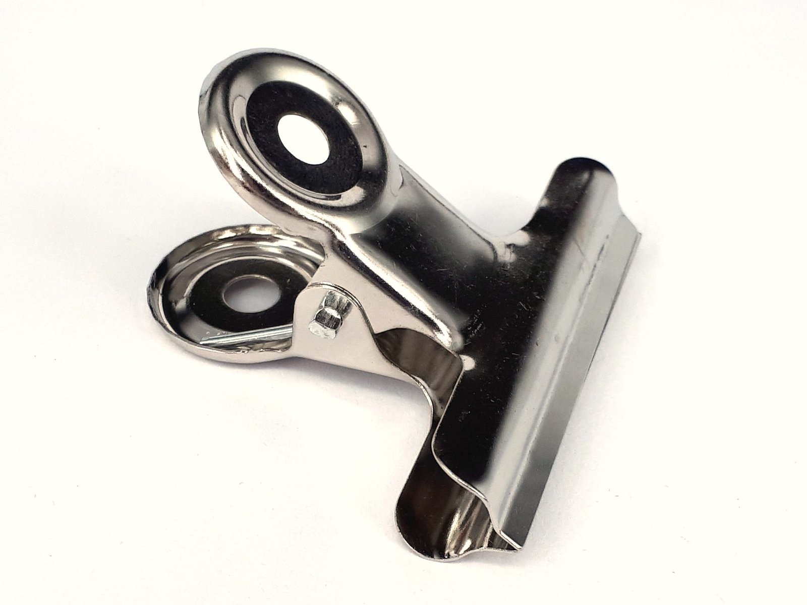 A steel bulldog clip on a white background
