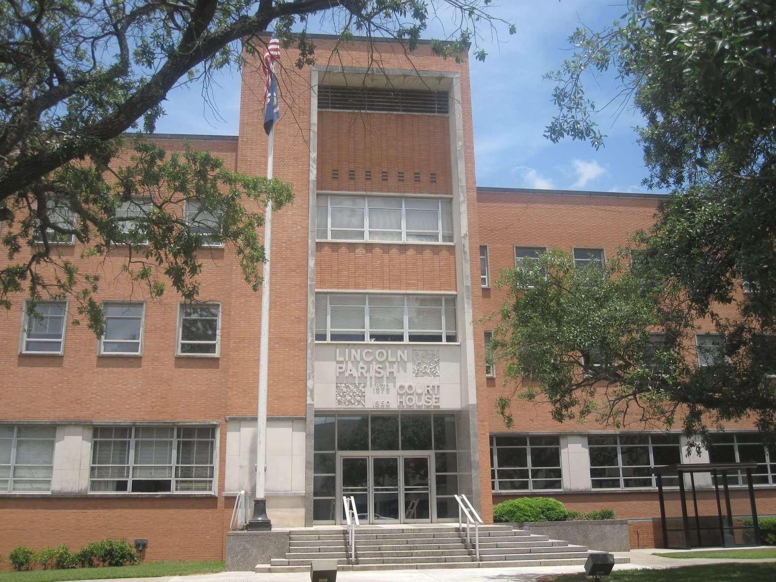 The brick and limestone front of the Lincoln Parish Courthouse in Ruston, framed by trees